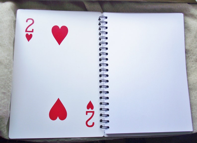 The center of the notebook features a playing card for stability.