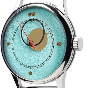 May include: A silver wristwatch with a mesh band and a light blue face. The watch face features a gold-colored crescent and a red second hand. The watch has a silver case and a crown on the side.