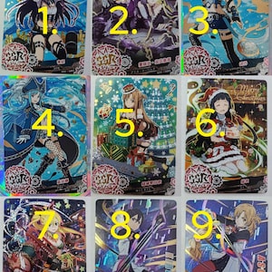 Peut inclure: Neuf cartes à collectionner avec des illustrations de style anime. Les cartes présentent divers personnages dans des costumes détaillés, avec des couleurs vives et des accents holographiques. Chaque carte a du texte japonais et un design unique, pour collectionneurs.