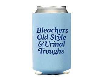May include: A light blue can cooler with the words "Bleachers Old Style & Urinal Troughs" in dark blue script. The cooler is designed to hold a standard-sized beverage can and keep it cold.