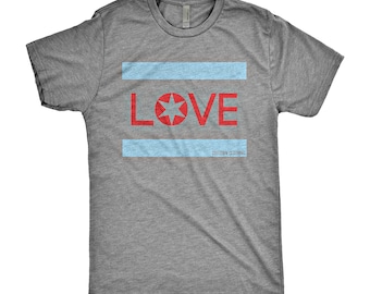 Könnte beinhalten: Ein meliertes graues T-Shirt mit einem roten Stern und dem Wort "LOVE" in Rot, mit zwei hellblauen horizontalen Streifen. Der Text "CHITOWN CLOTHING" ist darunter gedruckt. Das T-Shirt hat einen Rundhalsausschnitt.