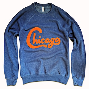 May include: A blue sweatshirt with a large orange "Chicago" graphic on the front.