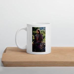 May include: A white ceramic mug featuring a printed image of a person with long brown hair wearing dark red and black traditional samurai armor, standing outdoors in a forest setting with green trees and foliage visible in the background.