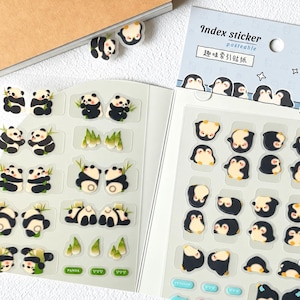 Puede incluir: Un conjunto de 66 pegatinas de índice con ilustraciones de pandas y pingüinos. Las pegatinas están dispuestas en dos hojas, con diseños de pandas que incluyen tallos de bambú y pingüinos en varias poses. El empaque incluye el texto Index sticker.