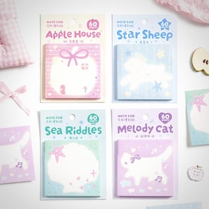 May include: Four packs of square sticky notes labeled Apple House, Star Sheep, Sea Riddles, and Melody Cat. Each pack contains 60 sheets with pastel-colored designs featuring an apple-shaped house, a sheep with stars, a seashell, and a cat.