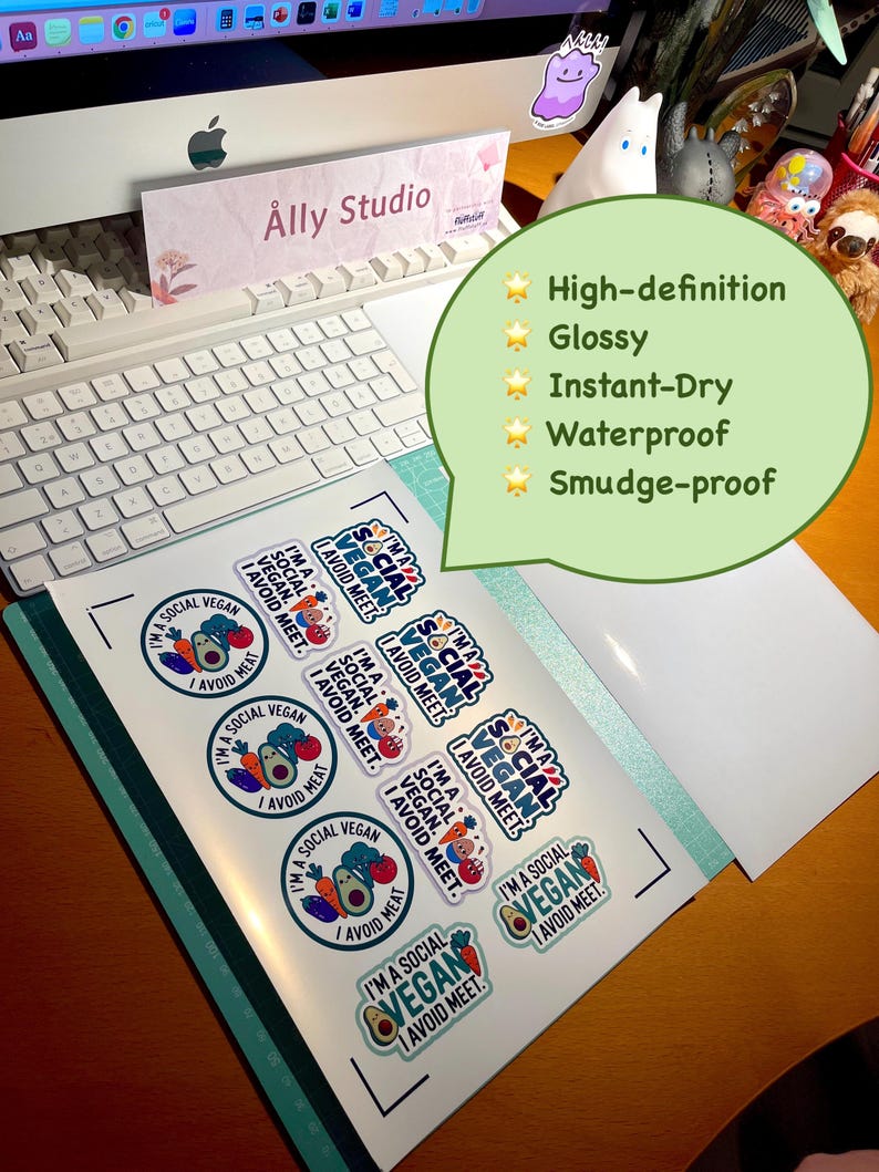 May include: A sheet of glossy, waterproof, and smudge-proof stickers featuring the text I'M A SOCIAL VEGAN I AVOID MEAT. The stickers include colorful illustrations of an avocado, carrot, and tomato, arranged in circular and rectangular shapes.