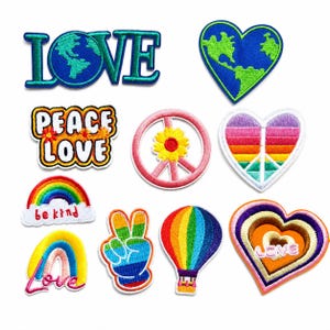 Puede incluir: Una colección de diez parches bordados con varios diseños, incluyendo la palabra LOVE con un globo terráqueo, un globo en forma de corazón, un letrero de PEACE LOVE, un símbolo de paz con una flor, un corazón arcoíris, un arcoíris y un globo.