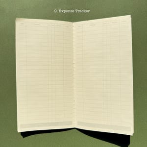 May include: An open expense tracker notebook with cream-colored pages featuring a printed grid layout for recording financial data. The top of the page displays the text 9. Expense Tracker, with columns labeled Date, Contents, Income, and Outlay.