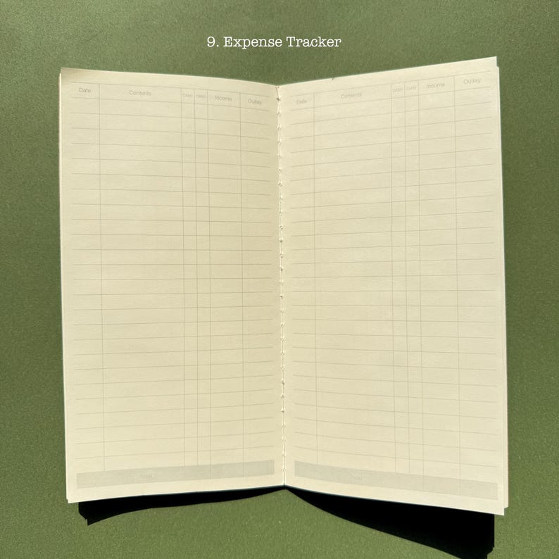 May include: An open expense tracker notebook with cream-colored pages featuring a printed grid layout for recording financial data. The top of the page displays the text 9. Expense Tracker, with columns labeled Date, Contents, Income, and Outlay.