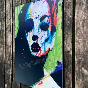 May include: A colorful abstract portrait print featuring a woman's face with vibrant watercolor paint splatters. The artwork includes the text "Art by Carissa Rose" and a signature. The color palette includes black, white, blue, red, and green.