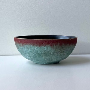 May include: A set of three ceramic mugs with a speckled, matte finish. Each mug features a different color: light blue, cream, and gray. The mugs have a simple, modern design and a comfortable handle.