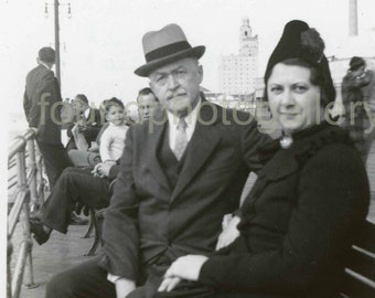 Elegant Man and Woman in Great Hats Sitting on Bench on a Boardwalk, Old Photo, Found Photo, 1930's √