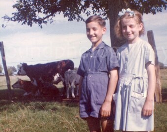 Vintage Photo, Smiling Brother and Sister in Stylish Blue Outfits Posing in Front of a Cow Field