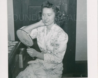 Beautiful Woman in Silk Floral Bathrobe Admiring Herself in Handheld Mirror Sitting in Bedroom, Vintage Photo