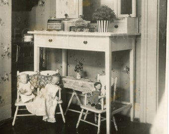 Children’s Room with Painted Vanity with Lovely Plant In Striped Vase, Dolls in Dolly Chairs, 1940’s Vintage Photo