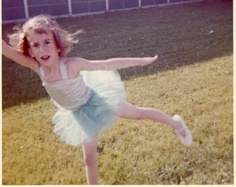 ¡Estoy volando! Dulce niña mostrando sus movimientos arabescos en un leotardo, tutú y zapatillas de ballet, foto de época