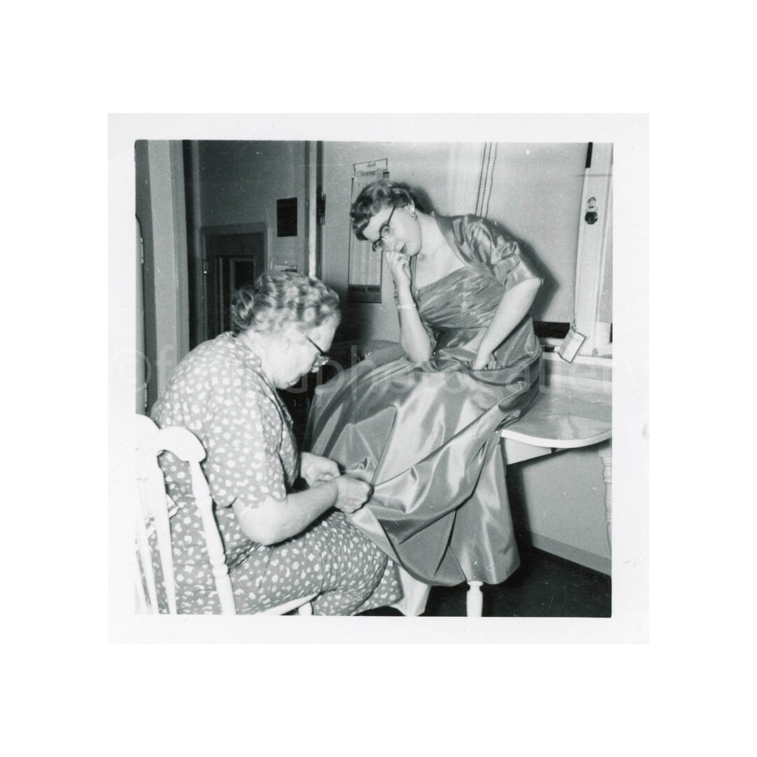 Woman Fixing Friend's Dress Hem in