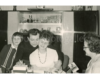 Loving Family Sitting Around Table Looking through Photo Albums, Vintage Photo, Snapshot