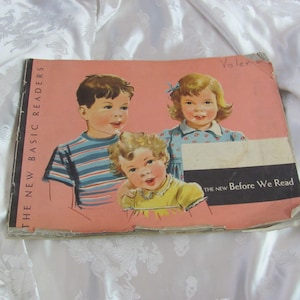 May include: A vintage book cover with the title "The New Basic Readers" and the text "The New Before We Read". The cover features three children, two girls and a boy, with a pink background.