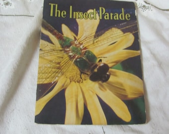 May include: A vintage children's book titled "The Insect Parade" with a colorful illustration of a dragonfly on a yellow flower.