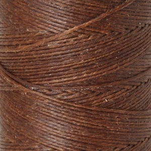 May include: A spool of dark brown waxed thread featuring a tightly twisted, multi-ply construction. The surface of the cord displays a distinct, textured fiber pattern with a matte finish, showing the continuous winding of the thread around the core.