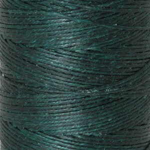 May include: Close-up of a spool of dark green waxed thread. The thread is tightly wound, showing a textured surface. The color is a deep, forest green, ideal for crafting and sewing projects.