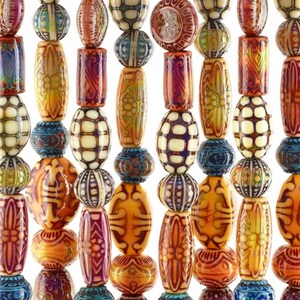 May include: A close-up of a collection of colourful beads in various shapes and sizes. The beads are strung together, showcasing a variety of patterns and colours, including orange, blue, yellow, and white. The beads have intricate designs.