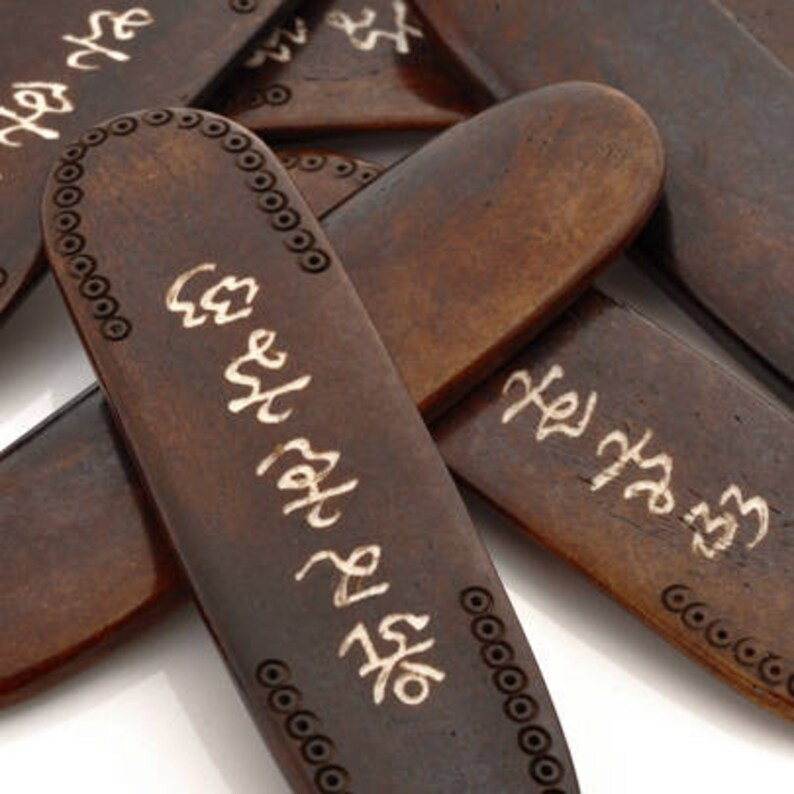 K&ouml;nnte beinhalten: Nahaufnahme eines Sets aus sechs braunen Holz-Lesezeichen mit goldenen Schriftz&uuml;gen. Jedes Lesezeichen hat eine andere Inschrift in koreanischer Sprache.
