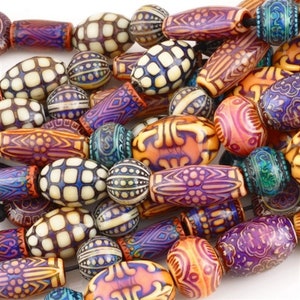 May include: A close-up of a collection of decorative beads in various shapes and sizes. The beads are in shades of orange, purple, blue, and cream, with intricate patterns. Some are oval, others round or cylindrical, creating a visually interesting assortment.