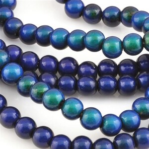 May include: Strands of round wooden beads in shades of blue and teal. The beads have a glossy finish and are strung together, creating a textured and colorful pattern. These beads are suitable for jewelry making and craft projects.