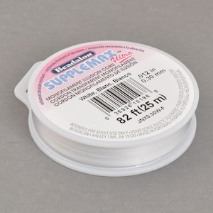 May include: A spool of Beadalon Supplemax Ultra monofilament illusion cord in white. The label indicates 82 ft (25 m) of .012 in (0.30 mm) cord. The product is intended for adult use only.