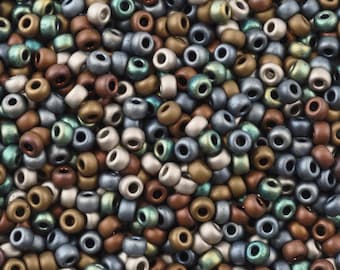 May include: A close-up of a large pile of small, round beads in various metallic colors, including silver, gold, copper, and green.