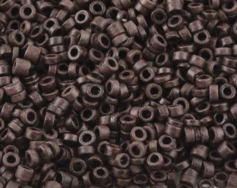May include: A pile of dark brown hair extension beads. The beads are cylindrical with a hole through the center. The beads are a solid color and appear to be made of a hard material.
