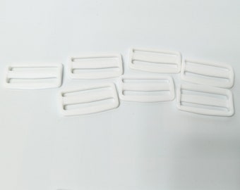 Seven white sliders, tri-bar slide adjusters, plastic, for 2" strap