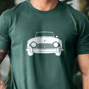 Puede incluir: Camiseta verde oscuro con un contorno blanco de un coche descapotable cl&aacute;sico. El dise&ntilde;o del coche incluye faros, una parrilla y un parabrisas. La camiseta est&aacute; hecha de un material suave, adecuada para uso casual.