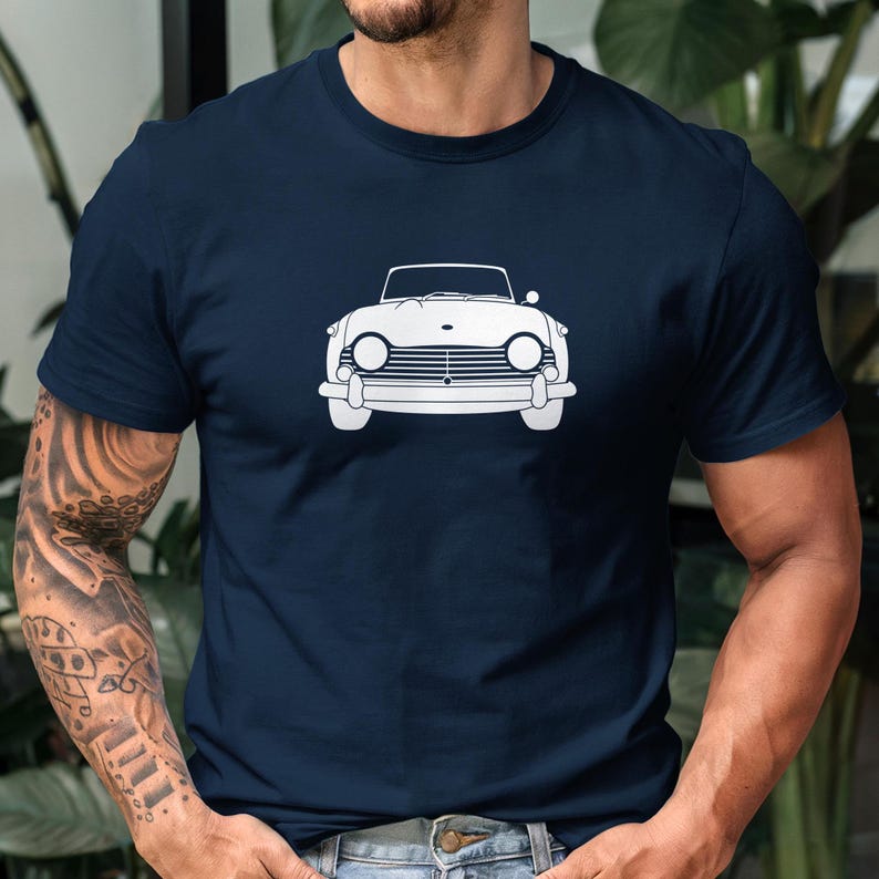 Puede incluir: Camiseta azul marino con un dibujo lineal blanco de un coche descapotable cl&aacute;sico. El dise&ntilde;o del coche, visto de frente, resalta los faros y la parrilla. La camiseta est&aacute; hecha de un tejido suave.