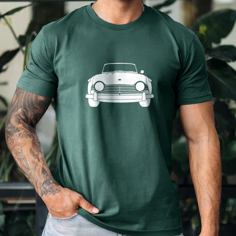 Puede incluir: Camiseta verde oscuro con un contorno blanco de un coche descapotable cl&aacute;sico. El dise&ntilde;o del coche incluye faros, una parrilla y un parabrisas. La camiseta est&aacute; hecha de un material suave, adecuada para uso casual.