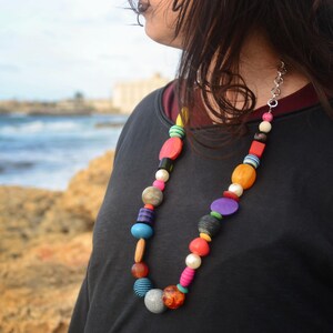 Collana realizzata con pietre di diverso materiale e catena in metallo argentato.