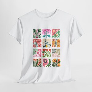 May include: White t-shirt featuring a colourful floral pattern. The pattern is made up of 16 squares, each containing a different floral design. The flowers are in shades of pink, red, orange, yellow, green, and blue.