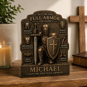 May include: A bronze-coloured plaque featuring a knight in armour with the text "PUT ON THE FULL ARMOR OF GOD" and labels for "HELMET OF SALVATION," "BREASTPLATE OF RIGHTEOUSNESS," "BELT OF TRUTH," "SHIELD OF FAITH," "SWORD OF THE SPIRIT," and "BOOTS OF PEACE."