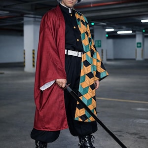以下が含まれることがあります： 黒い制服に白いベルトを合わせ、左右でデザインが異なる羽織を着用した衣装。片側は無地の濃い赤色で、もう片側は黄色、緑色、黒色の立方体が並ぶ幾何学模様。手には黒い刀を持っている。