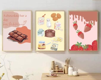 May include: Three framed prints with a pink background and a chocolate bar, a yellow background with baking ingredients, and a pink background with strawberries and chocolate sauce. The text on the first print reads "A chocolate bar a day keeps the doctor away".