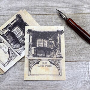May include: Two bookplates featuring an owl perched on a stack of books, candles, and the text "Ex Libris" on a beige background.