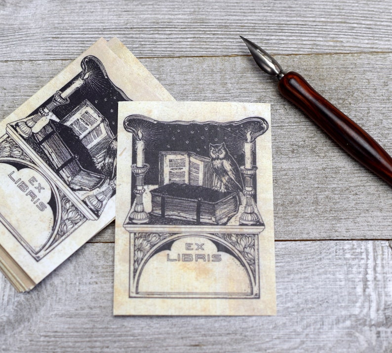May include: Two bookplates featuring an owl perched on a stack of books, candles, and the text "Ex Libris" on a beige background.