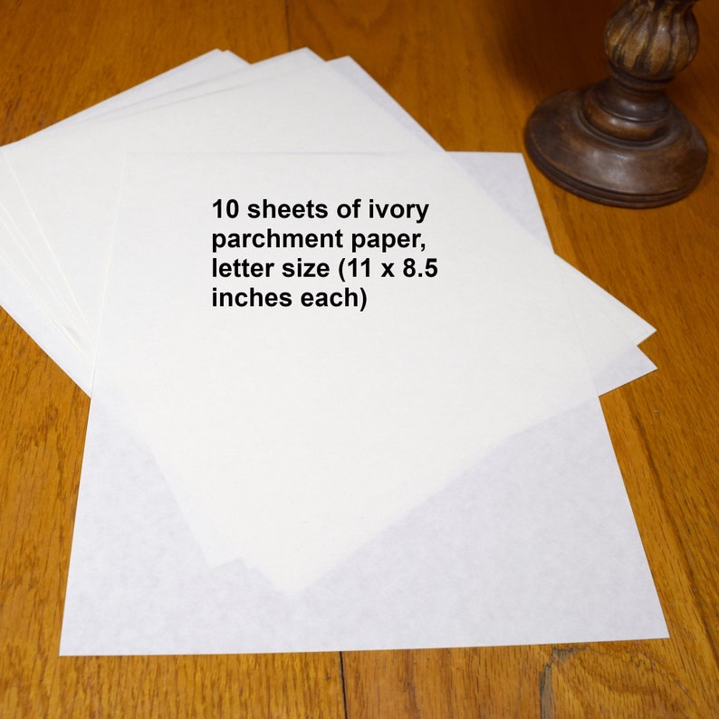 Photograph of 10 sheets of ivory parchment paper on a wood desk