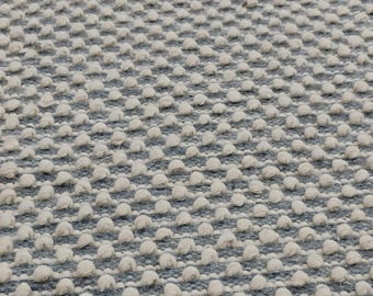 Alfombra moderna minimalista de lana con bucles gruesos en gris y blanco para sala de estar.