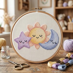 May include: A cross-stitch embroidery hoop featuring a smiling sun, star, and moon design. The sun is yellow and orange, the star is purple, and the moon is blue. The embroidery is set in a wooden hoop, perfect for home decor or craft projects.