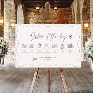 以下が含まれることがあります： 木製のイーゼルに立てられた白いウェディングサイン。エレガントな筆記体で「Order of the day」と表示されています。サインには、セレモニー、写真、カクテル、スピーチ、食事、ケーキ、パーティーのアイコンが付いたタイムラインが含まれています。「James & Charlotte」という名前と日付も含まれています。
