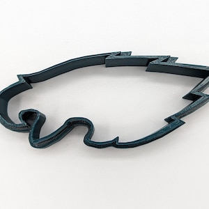 May include: A dark blue plastic cookie cutter shaped like an eagle's head.