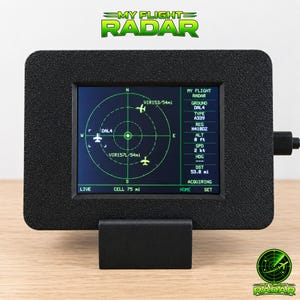 Peut inclure: Un appareil d'affichage radar de vol rectangulaire noir avec un cadre texturé et un support. L'écran affiche une interface radar circulaire verte avec des icônes d'avion, des marqueurs directionnels et le texte MY FLIGHT RADAR, DAL4, A339, N4100Z.